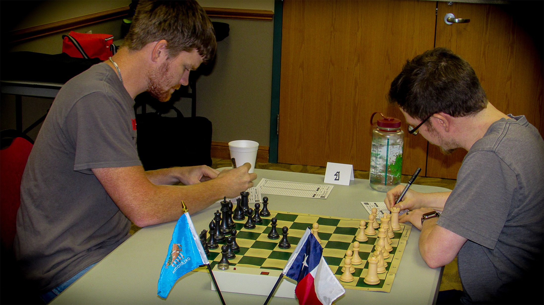On Board One, Chess Expert Logan Zachare (left) valiantly battled, in what had to be the toughest match of his career, against US Chess Original Life Chess Master Austen Green (right).  LM Green prevailed with a 2-0 sweep to help keep Texas close.  Photo by Mike Tubbs.